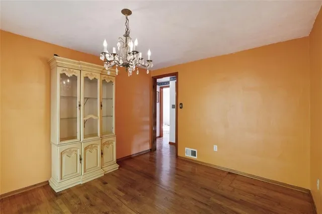 a very nice looking room with wooden floor and chandelier