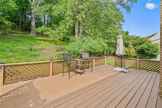 a view of deck with furniture and trees