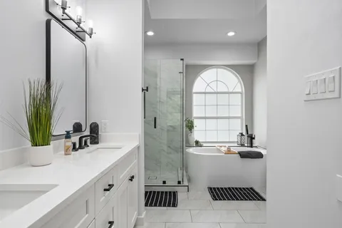 a bathroom with a double vanity sink window and mirror