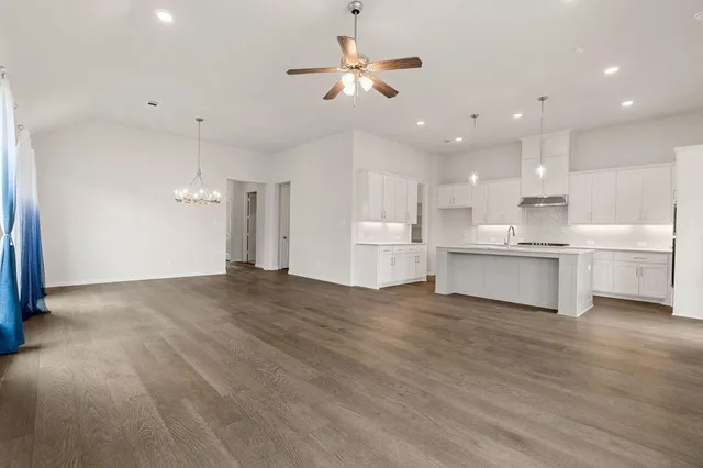a view of kitchen with kitchen island sink stove and white cabinets