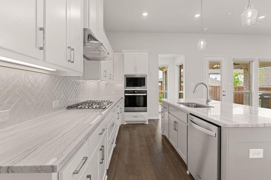 1636 Hydrangea Lane Prosper, TX 75078 - Photo 16 of 31 a kitchen with stainless steel appliances granite countertop a stove and a sink