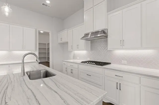 a kitchen with kitchen island a sink stainless steel appliances and wooden floor