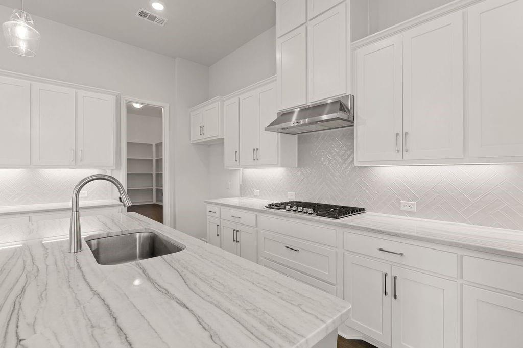 1636 Hydrangea Lane Prosper, TX 75078 - Photo 17 of 31 a kitchen with white cabinets appliances and sink