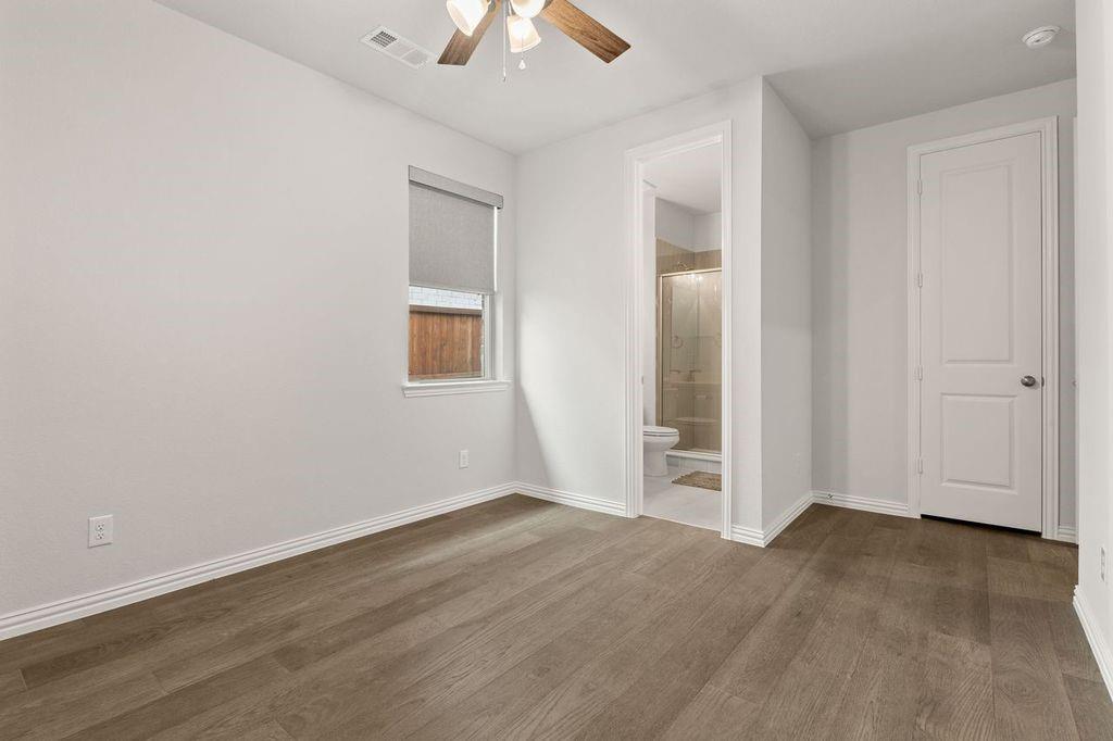 1636 Hydrangea Lane Prosper, TX 75078 - Photo 22 of 31 an empty room with wooden floor chandelier fan and windows