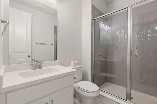 an empty room with chandelier fan and windows