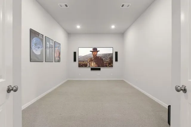 a view of an empty room with wall painting and a fan