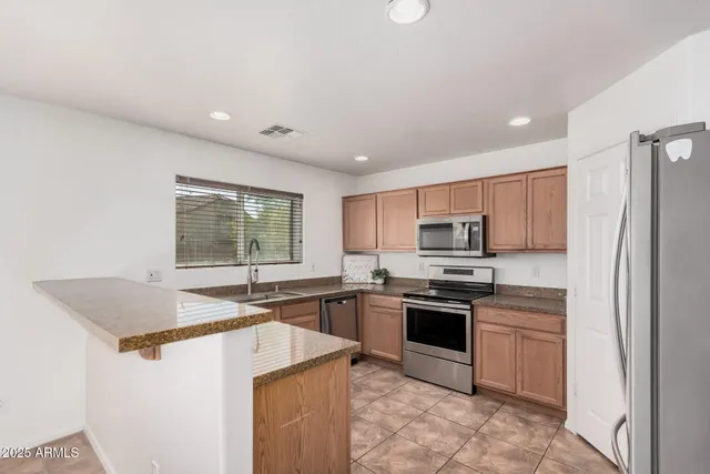 a kitchen with stainless steel appliances granite countertop a sink stove and refrigerator