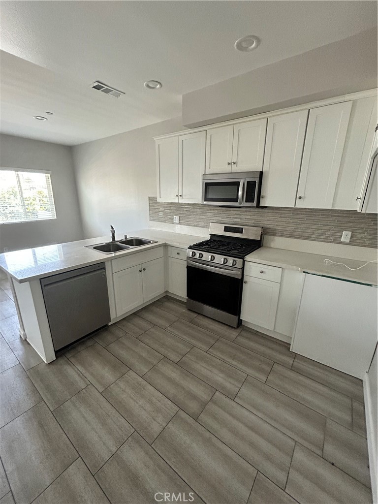 13665 Arrow Route, Unit 9 Fontana, CA 92335 - Photo 12 of 43 a kitchen with stainless steel appliances granite countertop a stove sink and cabinets
