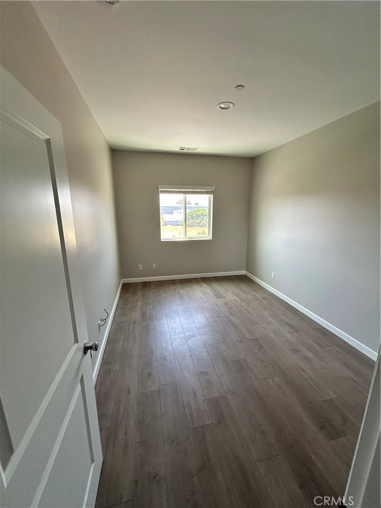 13665 Arrow Route, Unit 9 Fontana, CA 92335 - Photo 21 of 43 an empty room with wooden floor and windows