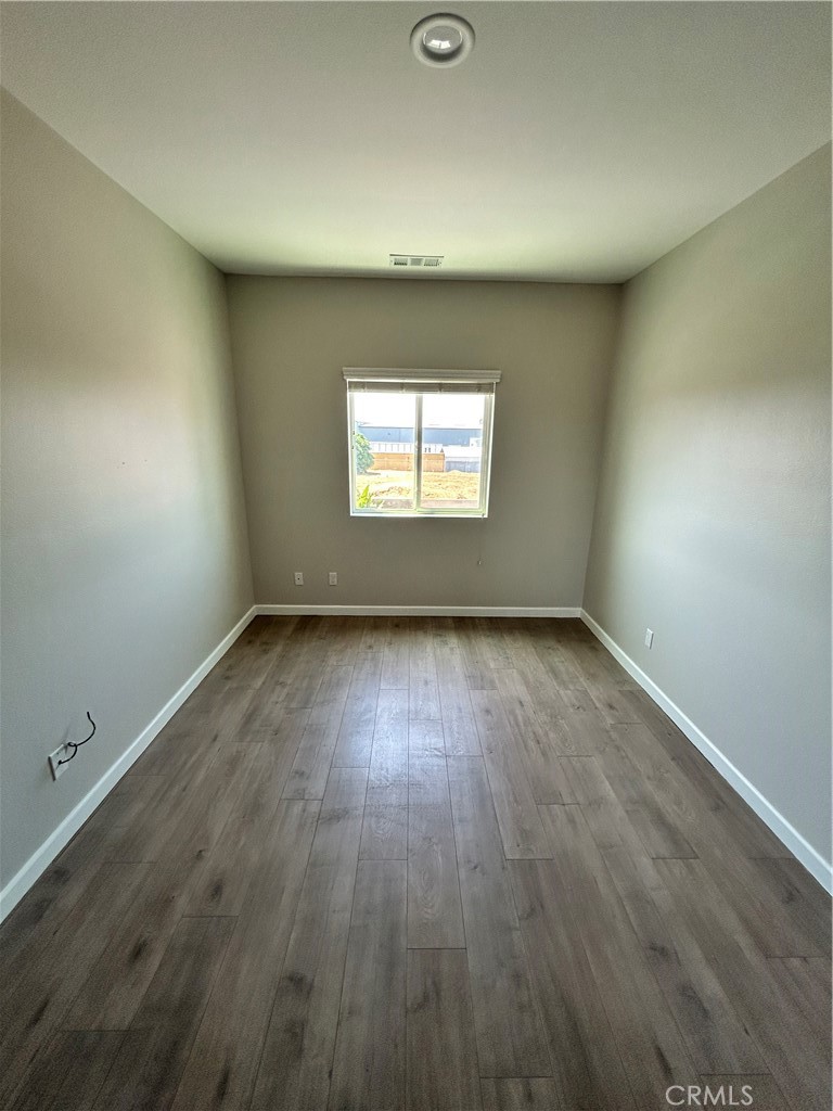 13665 Arrow Route, Unit 9 Fontana, CA 92335 - Photo 22 of 43 an empty room with wooden floor and windows
