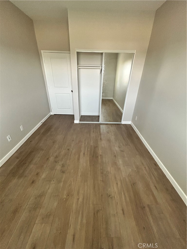 13665 Arrow Route, Unit 9 Fontana, CA 92335 - Photo 25 of 43 wooden floor in an empty room with a mirror