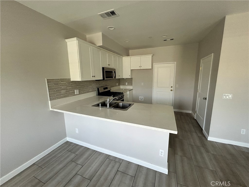 13665 Arrow Route, Unit 9 Fontana, CA 92335 - Photo 4 of 43 a kitchen with stainless steel appliances a sink a stove a refrigerator and cabinets