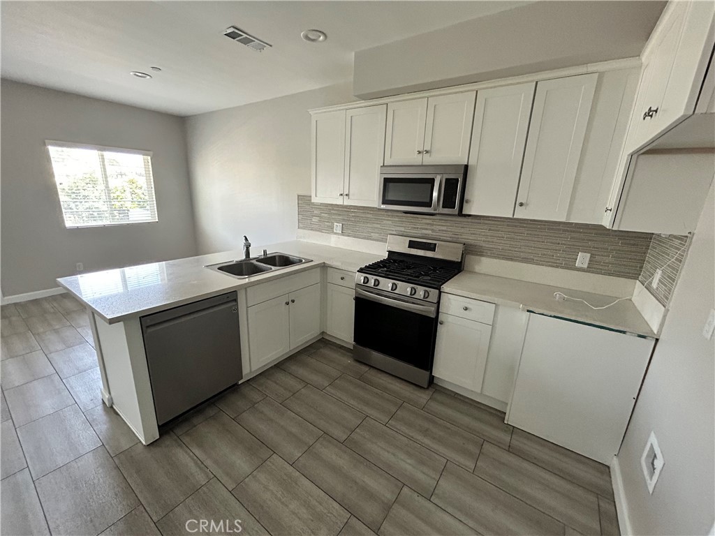 13665 Arrow Route, Unit 9 Fontana, CA 92335 - Photo 7 of 43 a kitchen with stainless steel appliances granite countertop a sink stove and refrigerator