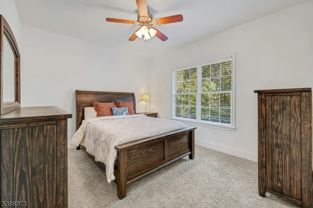 a bedroom with a bed and a flat tv screen on dresser