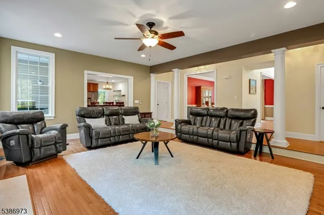 a living room with furniture ceiling fan and a large window