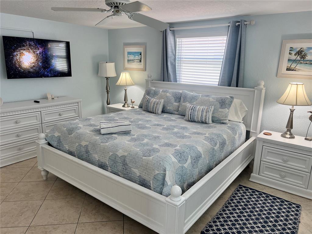 6154 Midnight Pass Road, Unit B11 Sarasota, FL 34242 - Photo 11 of 15 a bedroom with a bed and a flat screen tv