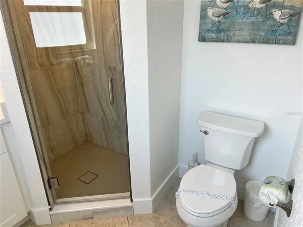 a white toilet sitting next to a shower