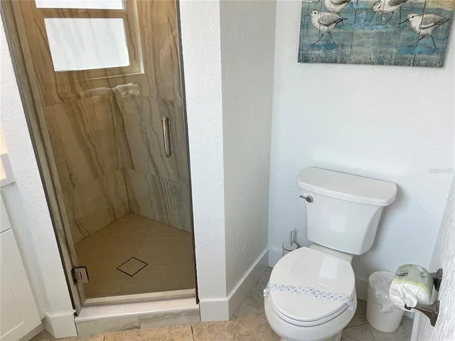 a white toilet sitting next to a shower