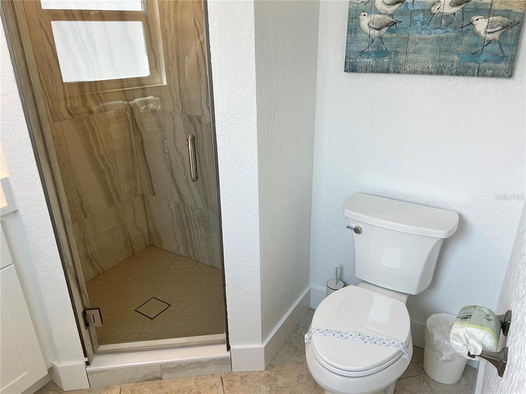 6154 Midnight Pass Road, Unit B11 Sarasota, FL 34242 - Photo 15 of 15 a white toilet sitting next to a shower