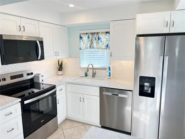 a kitchen with cabinets stainless steel appliances and sink