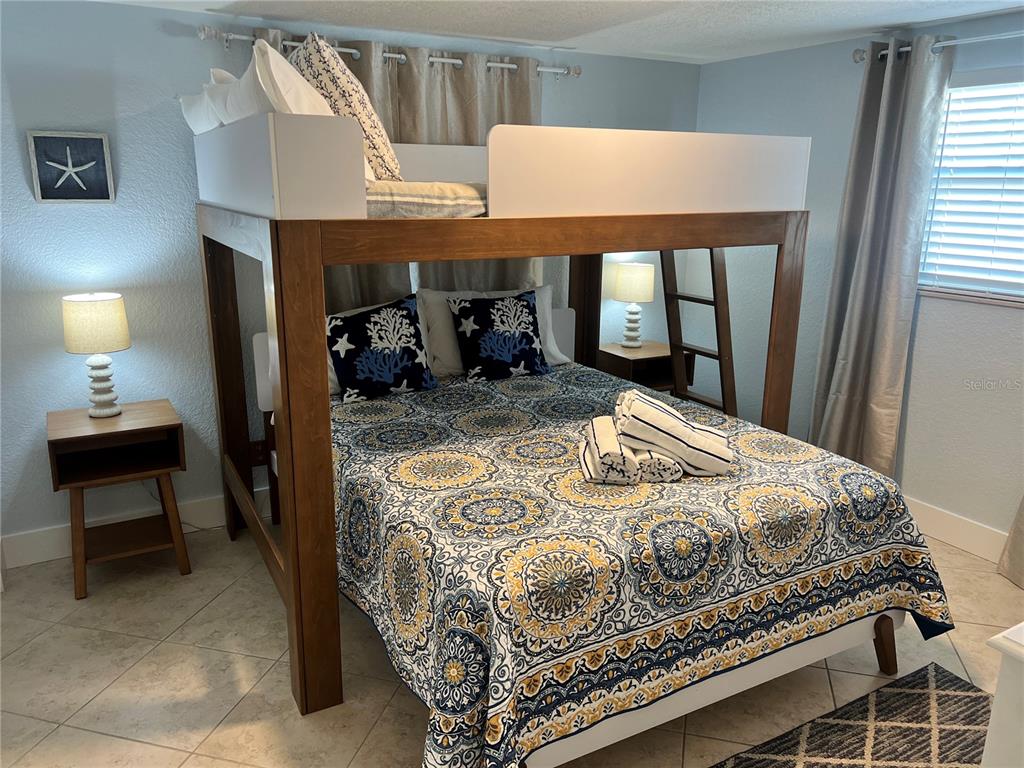 6154 Midnight Pass Road, Unit B11 Sarasota, FL 34242 - Photo 9 of 15 a bedroom with a bed and a table in it