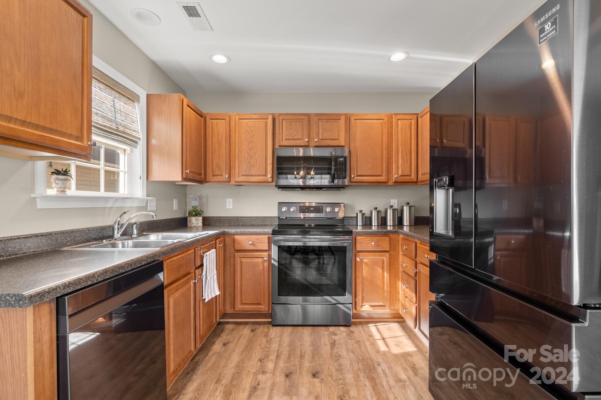 290 West Swift Creek Road Fletcher, NC 28732 - Photo 9 of 33 a kitchen with stainless steel appliances granite countertop a stove a sink dishwasher a refrigerator and a microwave oven with wooden floor