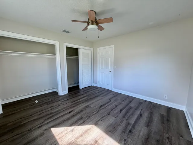 a view of room with hardwood floor and ceiling fan