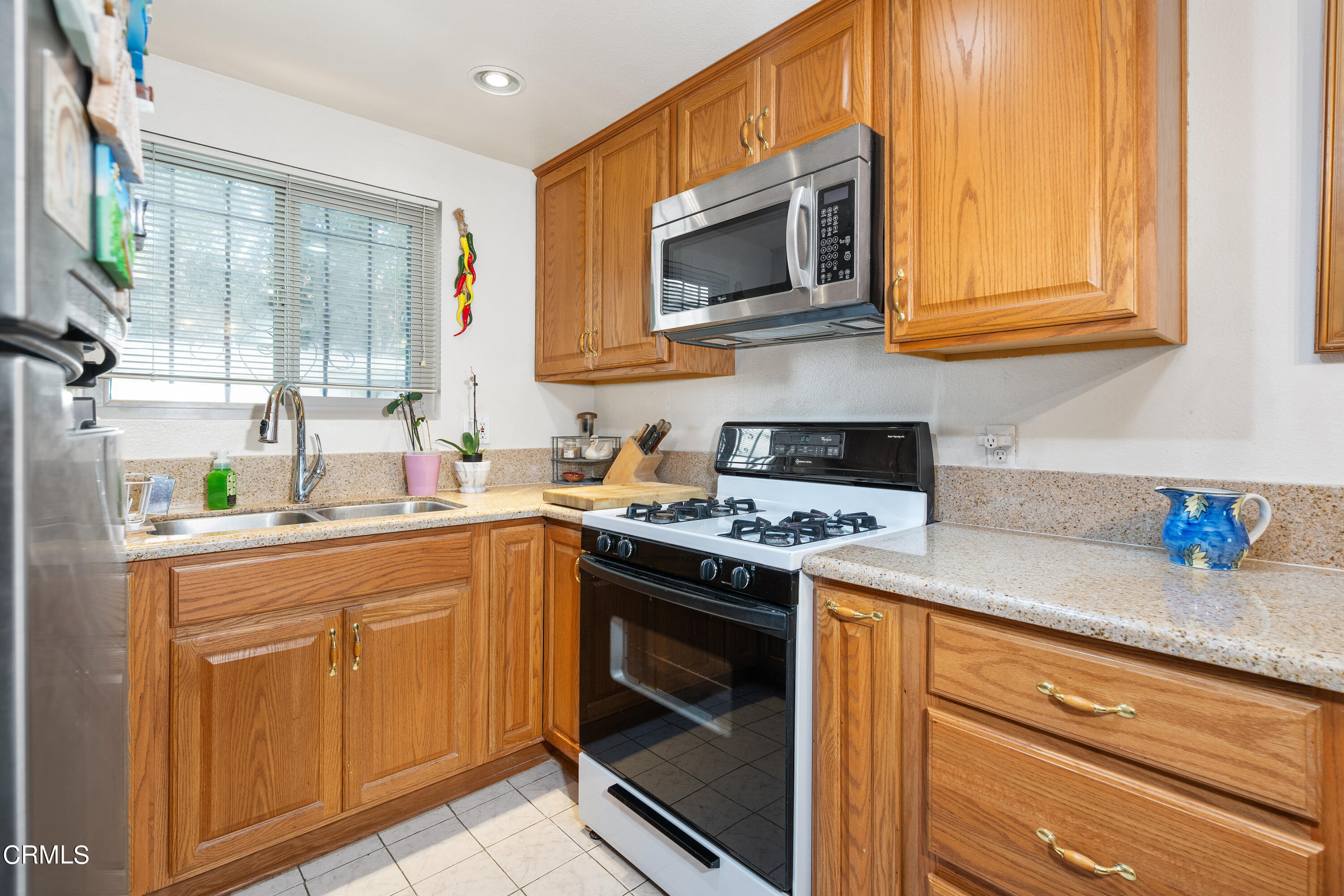 5170 North River Road, Unit C Oceanside, CA 92057 - Photo 13 of 43 a kitchen with stainless steel appliances granite countertop a sink stove and microwave