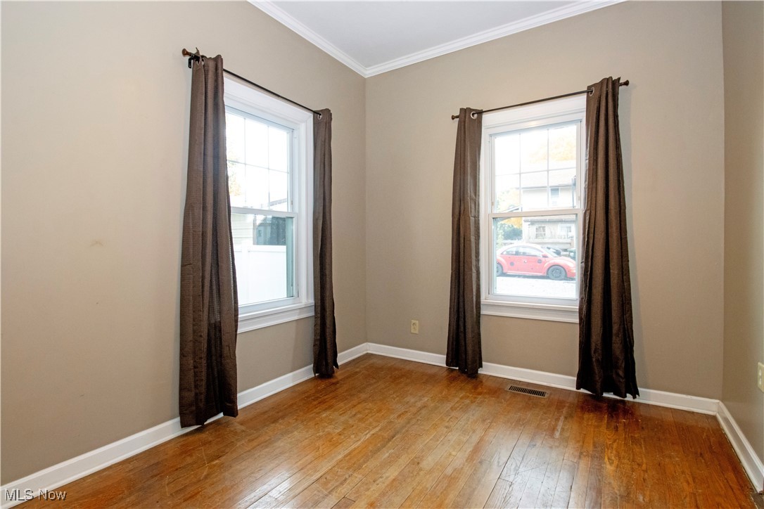 5699 Massillon Road Dalton, OH 44618 - Photo 10 of 24 Unfurnished room with ornamental molding, a wealth of natural light, and light wood-type flooring