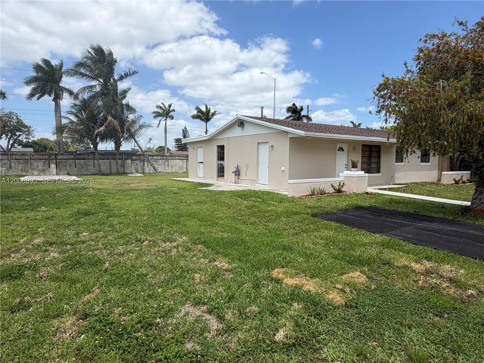10375 Southwest 152nd Terrace Miami, FL 33157 - Photo 3 of 59 a view of a house with a big yard and palm trees