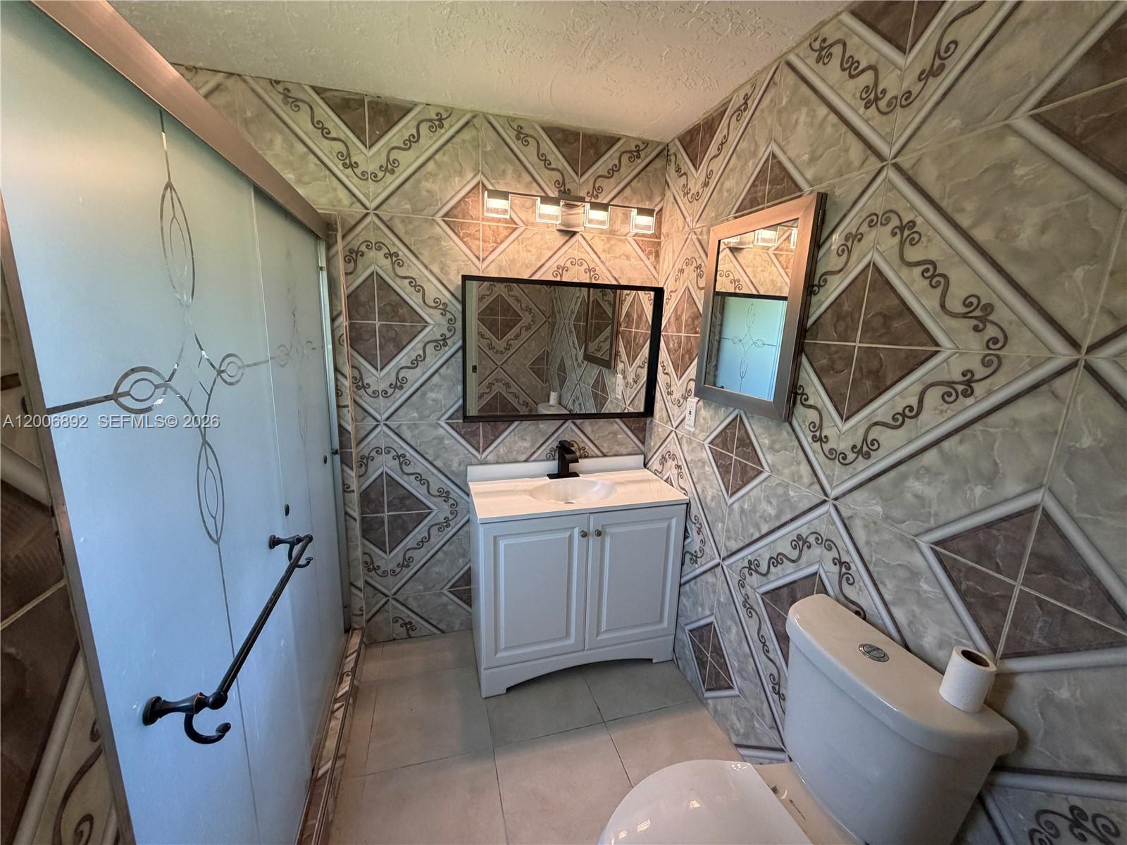 10375 Southwest 152nd Terrace Miami, FL 33157 - Photo 54 of 59 a bathroom with a sink a toilet and a mirror