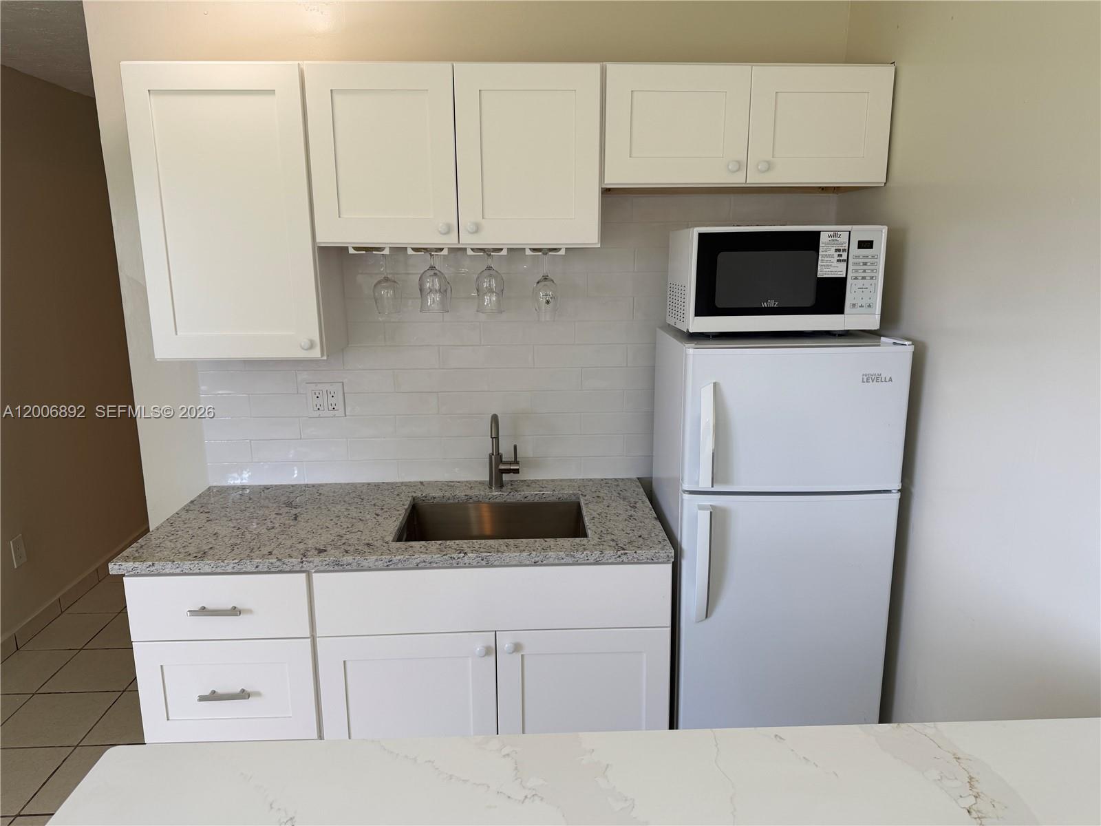 10375 Southwest 152nd Terrace Miami, FL 33157 - Photo 56 of 59 a kitchen with white cabinets and white appliances