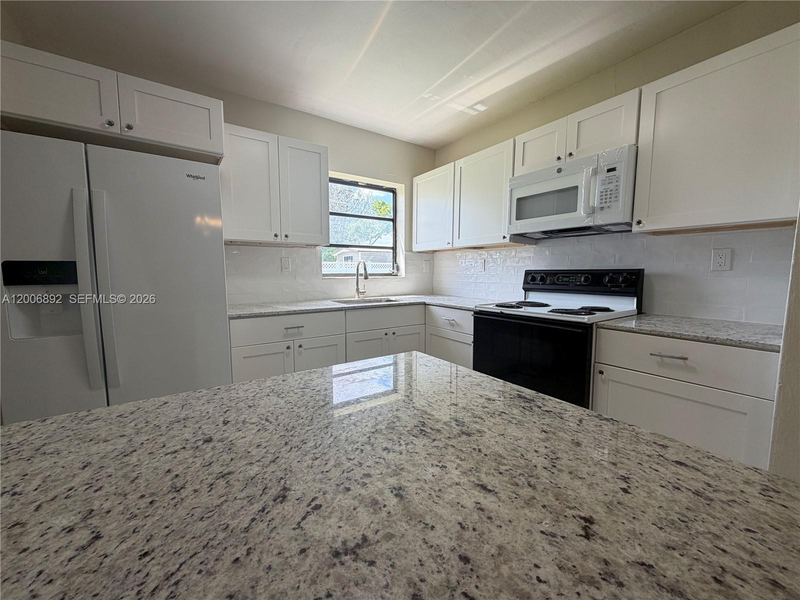 10375 Southwest 152nd Terrace Miami, FL 33157 - Photo 9 of 59 a kitchen with granite countertop a sink stove and refrigerator