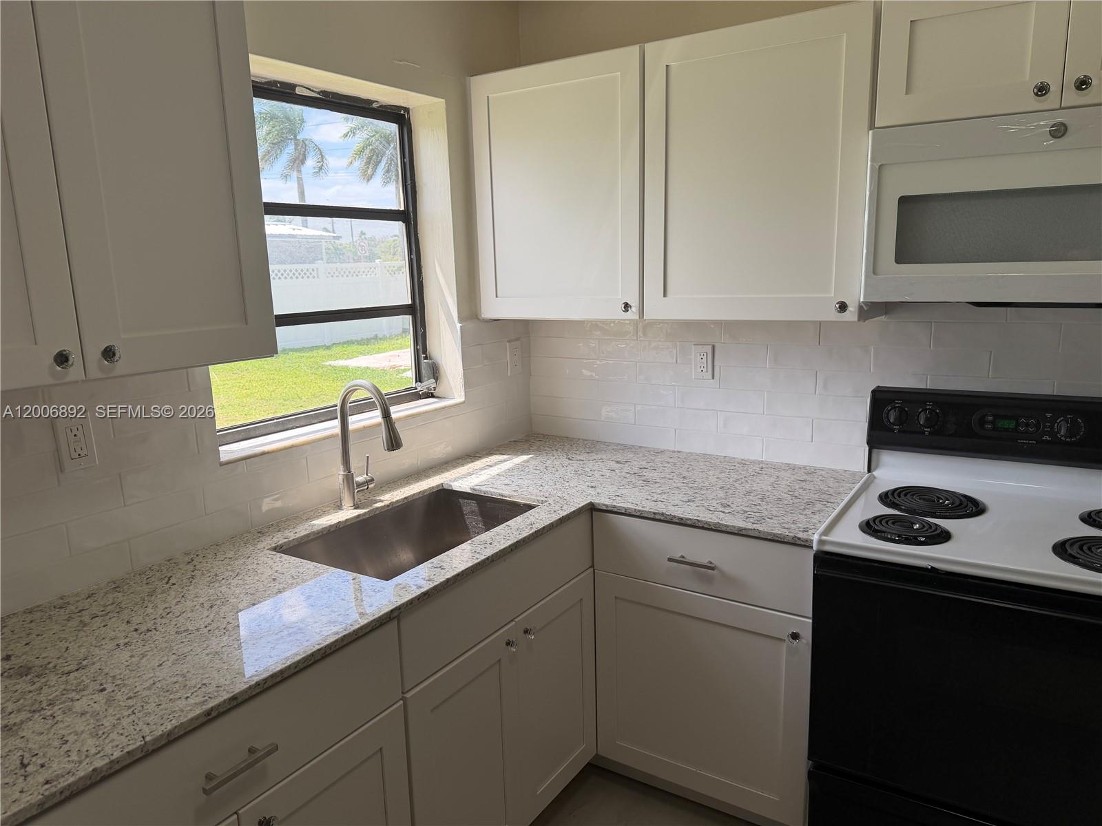 10375 Southwest 152nd Terrace Miami, FL 33157 - Photo 10 of 59 a kitchen with granite countertop white cabinets and a sink