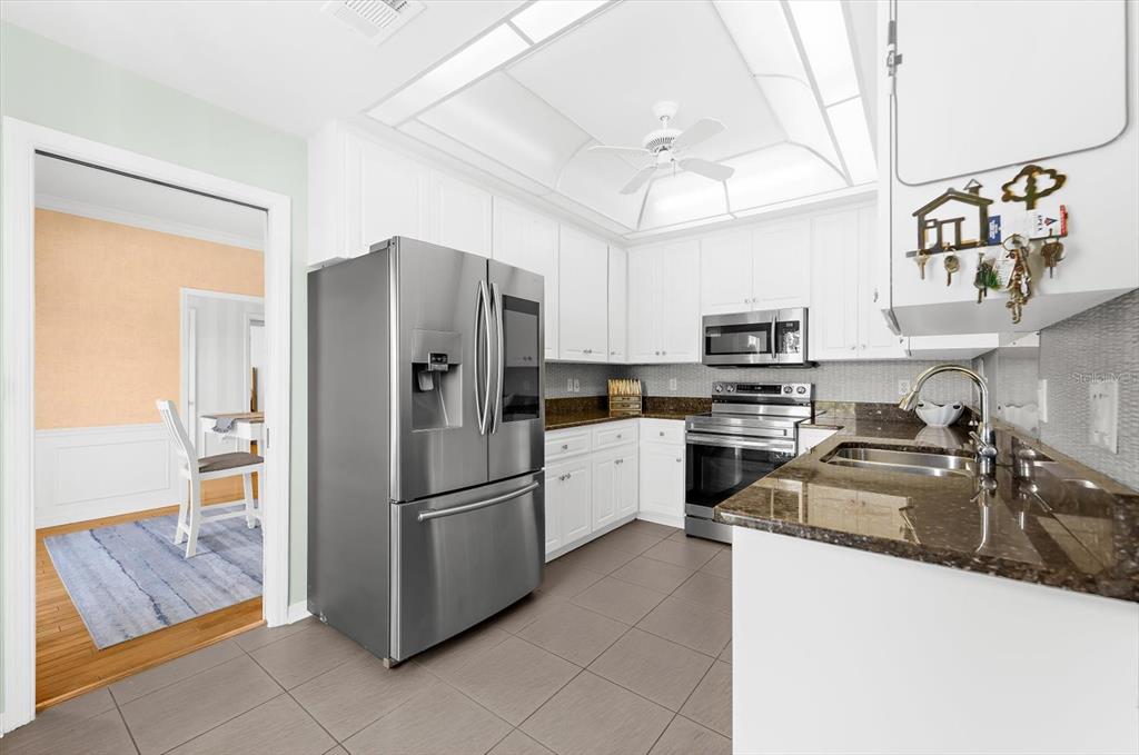 5 Barbados Road, Unit 31 Englewood, FL 34223 - Photo 6 of 40 a kitchen with stainless steel appliances granite countertop a refrigerator a stove a sink and a microwave