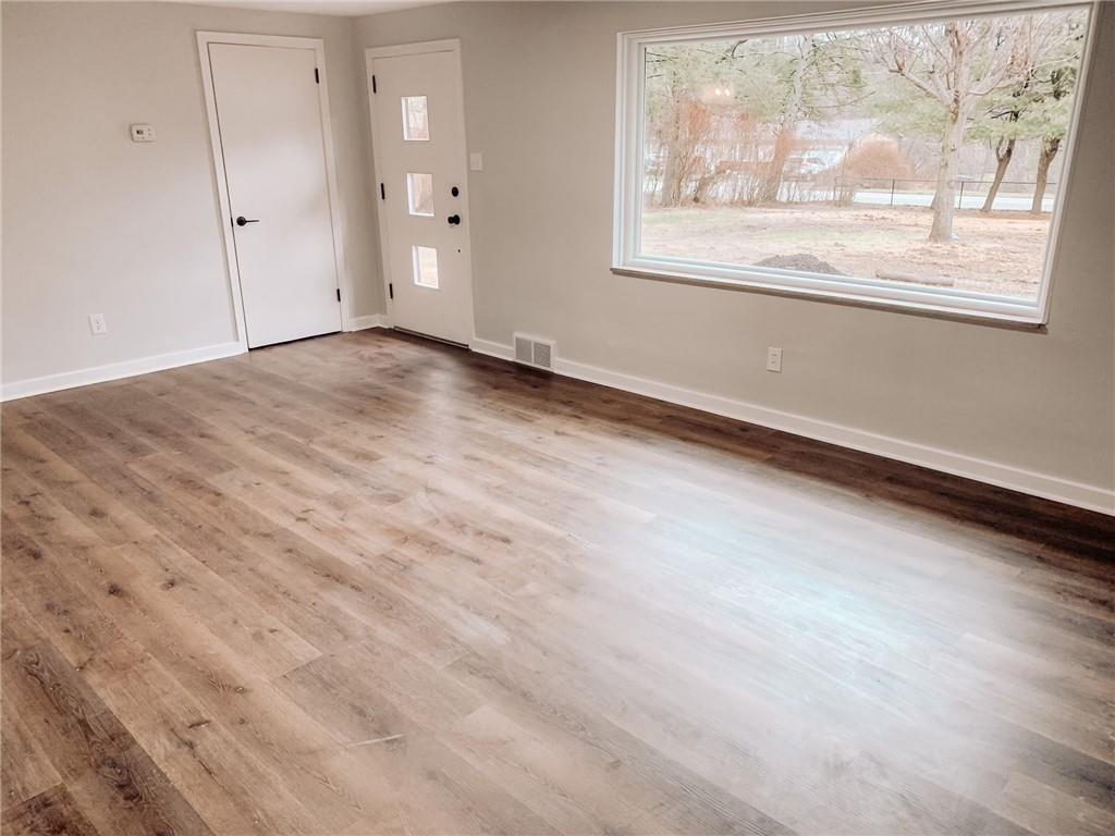 604 New Texas Road Pittsburgh, PA 15239 - Photo 7 of 18 an empty room with wooden floor and windows