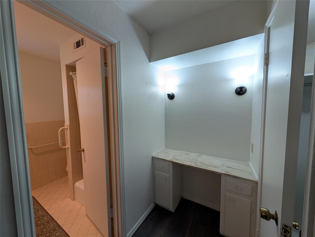 4715 Skillman Street, Unit A Dallas, TX 75206 - Photo 22 of 28 Vanity area featuring a built-in countertop with integrated cabinetry, wall-mounted sconces, and dark wood-finish flooring