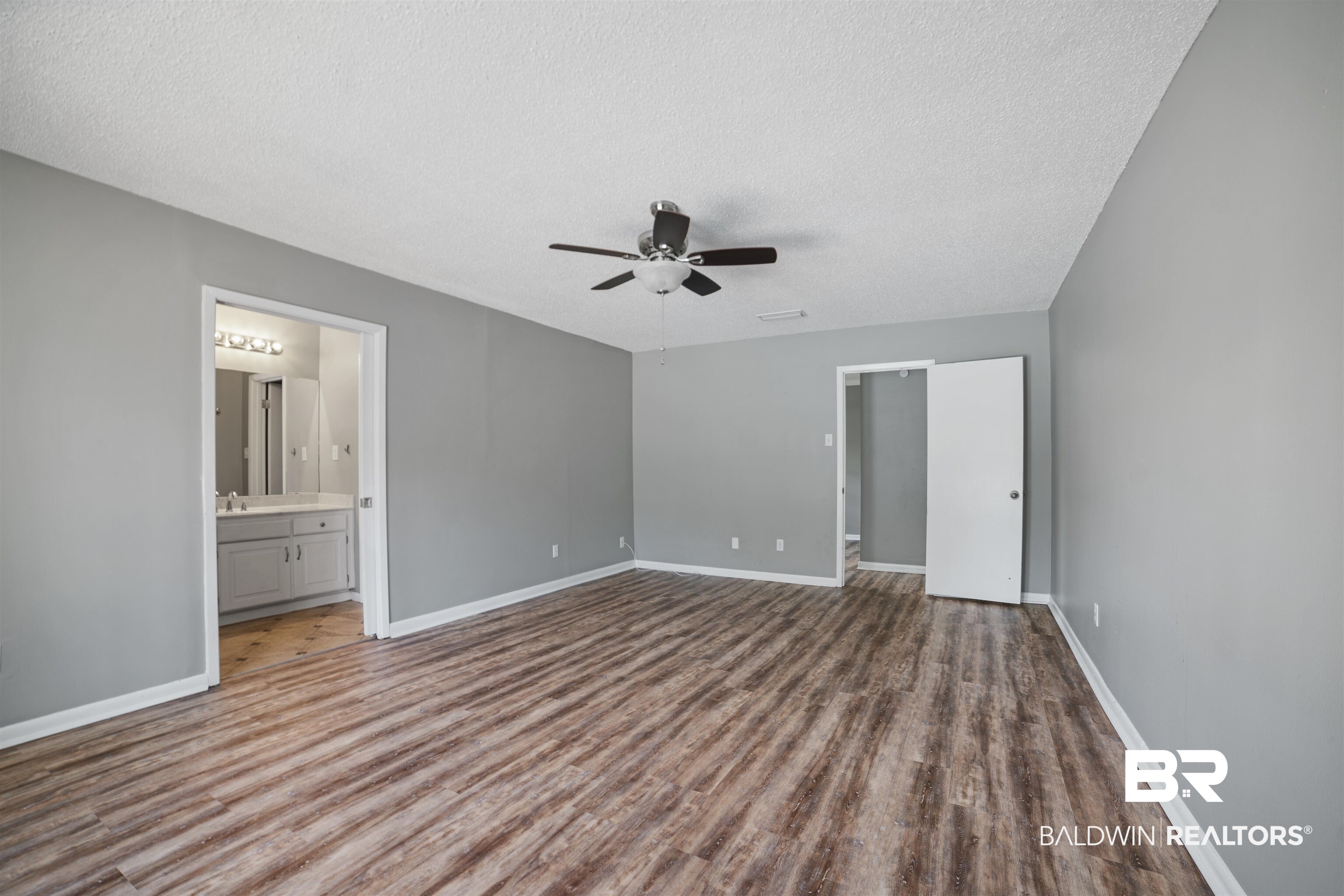 804 Regents Drive West Mobile, AL 36609 - Photo 19 of 35 Unfurnished bedroom with a textured ceiling, wood finished floors, ensuite bath, and a ceiling fan
