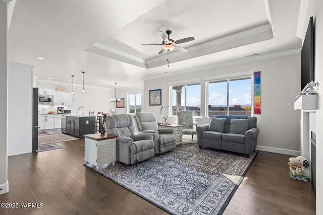 a kitchen with stainless steel appliances granite countertop a stove refrigerator and a dining table with wooden floor