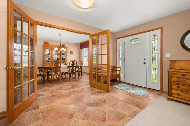 a dining room with furniture a chandelier and wooden floor