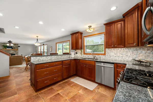 a kitchen with granite countertop sink and cabinets