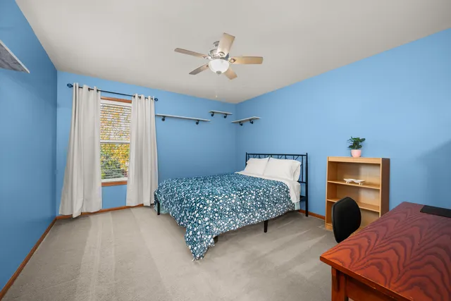 a bedroom with a bed and a ceiling fan