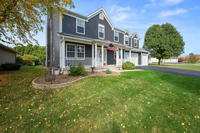 a front view of a house with garden and trees