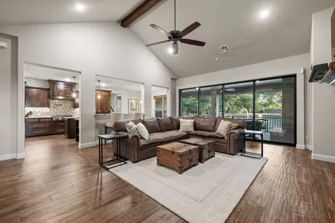 a living room with furniture and a large window with wooden floor