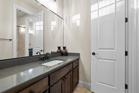 a bathroom with a granite countertop sink toilet and mirror