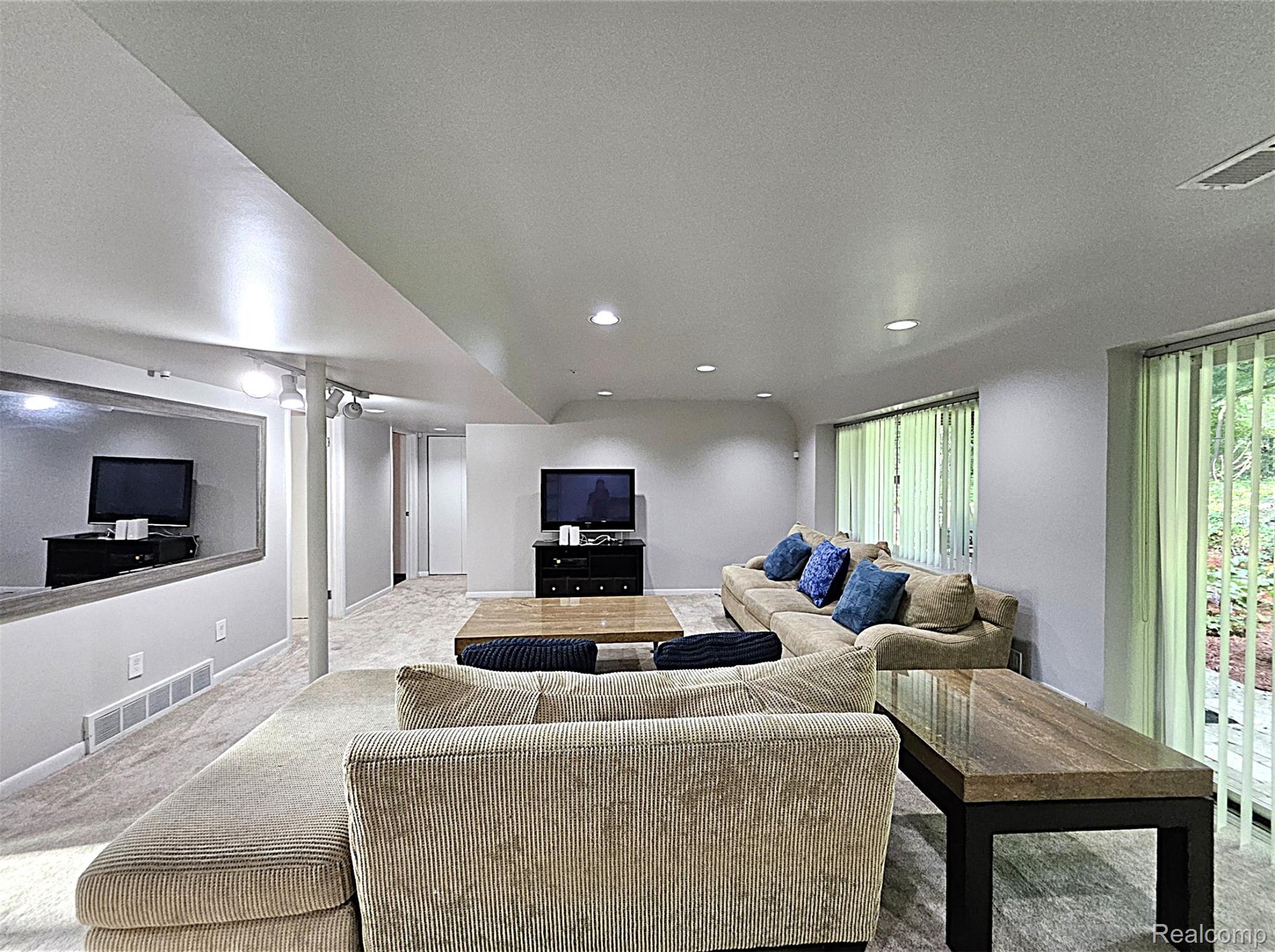 7120 Pebblecreek Road West Bloomfield, MI 48322 - Photo 29 of 31 Spacious lower level featuring recessed lighting, large windows with vertical blinds, light gray wall paint, light-toned carpeting, and a built-in mirror