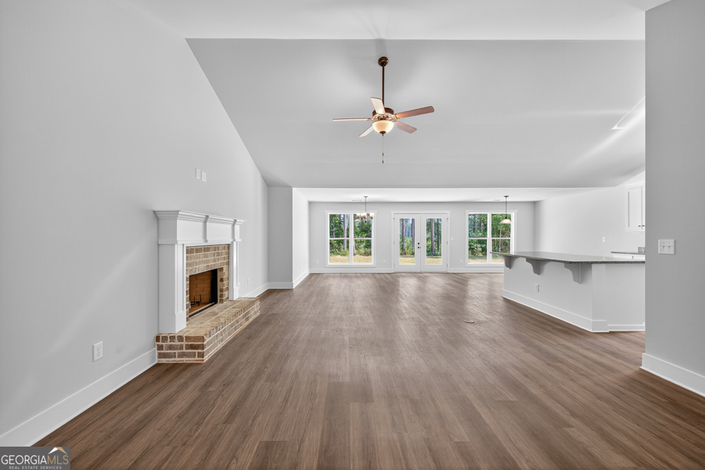 373 Liberty Hill Road, Unit 19 Hartwell, GA 30643 - Photo 4 of 31 an empty room with wooden floor fireplace and windows