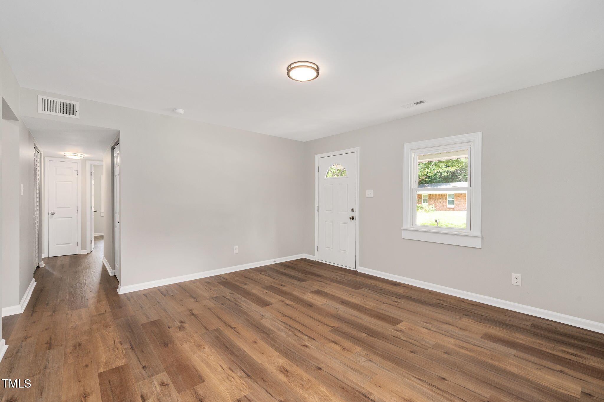 529 Solar Drive Raleigh, NC 27610 - Photo 5 of 18 a view of an empty room with wooden floor and a window