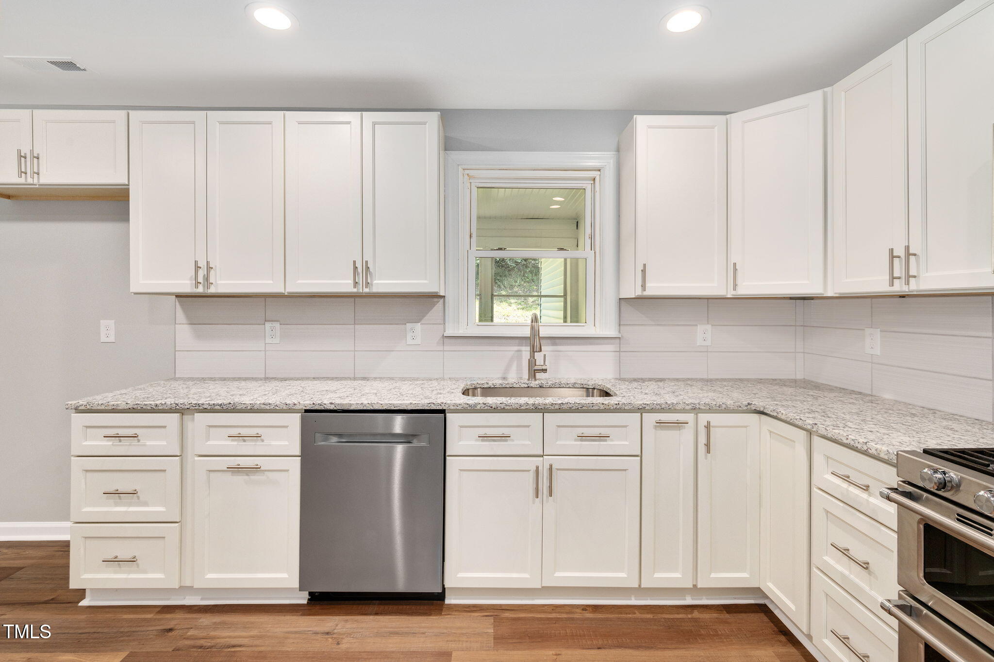 529 Solar Drive Raleigh, NC 27610 - Photo 7 of 18 a kitchen with granite countertop white cabinets and stainless steel appliances