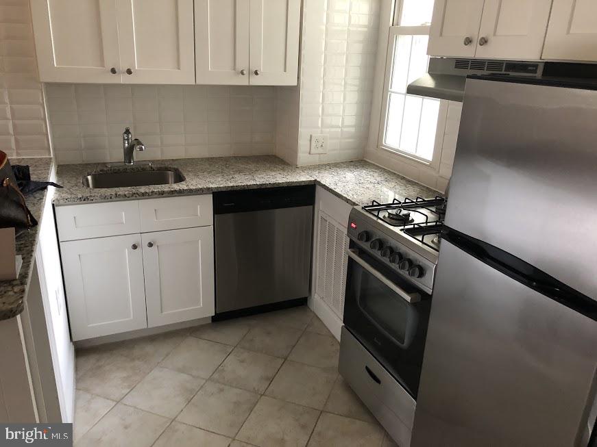 753 South 22nd Street Philadelphia, PA 19146 - Photo 18 of 22 a kitchen with granite countertop a stove sink and cabinets